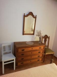 1 dormitorio con tocador, espejo y silla en Apartamento Tiago, en Sines