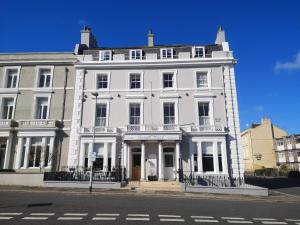 een groot wit gebouw op de hoek van een straat bij Invicta Hotel in Plymouth