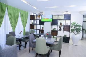 Andromeda Hotel في أديس أبابا: غرفة طعام بها طاولات وكراسي وتلفزيون