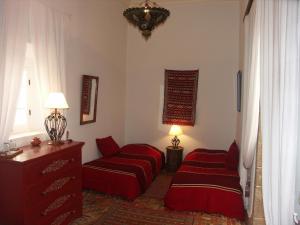 a hotel room with two beds and two lamps at Dar Ness in Essaouira
