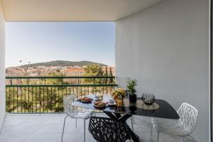 ein Esszimmer mit einem Tisch und Stühlen sowie einem Balkon in der Unterkunft Carmen - Luxury 2-Bedroom Apartment - Downtown in Split
