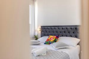 ein Schlafzimmer mit einem Bett mit weißen Laken und Kissen in der Unterkunft Carmen - Luxury 2-Bedroom Apartment - Downtown in Split