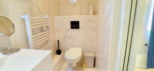 a white bathroom with a toilet and a sink at Citizenhouse - Gare in Valenciennes +16 photos