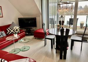 ein Wohnzimmer mit einem roten Sofa und einem Tisch in der Unterkunft Apartment Orchidee in Mülheim an der Ruhr