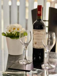 ミュルハイム・アン・デア・ルールにあるApartment Orchideeのワイン1本とワイングラス2杯(テーブル上)