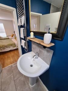 a bathroom with a sink and a mirror and a bed at Cooper's A favourite place to stay of many travellers to Burton-upon-Trent in Burton upon Trent