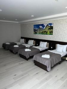 una habitación con 4 camas y un cuadro en la pared en Elite Hotel, en Bălţi