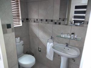 a small bathroom with a toilet and a sink at Turn and slip in Bloemfontein