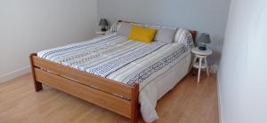 a large bed with a wooden frame in a room at La plage in Audierne