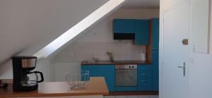 a kitchen with blue cabinets and a table with a blender at La plage in Audierne