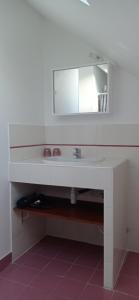 a white bathroom with a sink and a mirror at La plage in Audierne +4 photos
