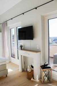 ein Wohnzimmer mit einem Kamin und einem TV darüber. in der Unterkunft Ferienwohnung Baltic Idyll in Scharbeutz