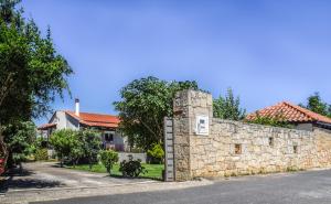 a stone wall in front of a house at Ambelaki Polythea in Kardhoulianós