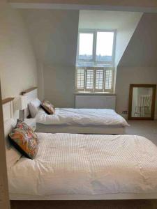 a bedroom with two beds and a window at Keeper's Rest in Cromer