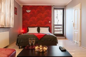 a bedroom with a bed with a red wall at Willa Róż in Międzyzdroje