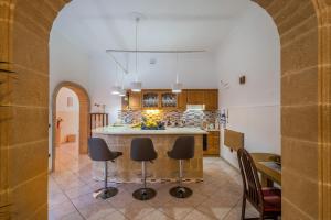una cucina con arco, tavolo e sedie di Casa Vacanza Patrizia a Guagnano