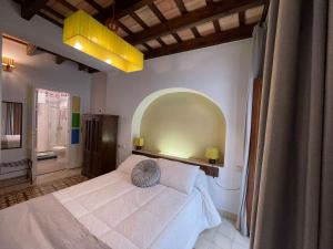 a bedroom with a white bed and a yellow light at Vagamundos in Tarifa