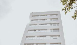 a tall white building against a cloudy sky at Corrientes Premium con desayuno in Bahía Blanca