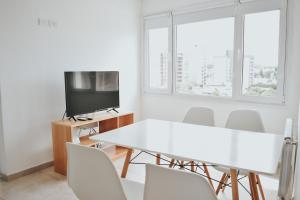 uma sala de jantar branca com uma mesa e cadeiras brancas em Corrientes Premium con desayuno em Bahía Blanca