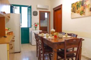 una sala da pranzo con tavolo e sedie e una cucina di Lo Spioncino Apartments a Otranto