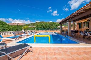 a swimming pool with lounge chairs and an umbrella at Ideal Property Mallorca - Villa Bona Vista in Capdepera