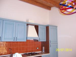 a kitchen with blue cabinets and a stove top oven at Ni La Za Ciccina in Castellammare del Golfo