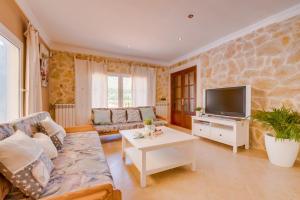 a living room with a couch and a tv at Ideal Property Mallorca - Villa Bona Vista in Capdepera