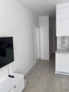 una camera bianca vuota con televisore e cucina di GoldenRise a Danzica
