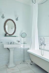 a bathroom with a sink and a tub and a mirror at Poseidonion Grand Hotel in Spetses