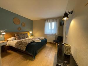 Una cama o camas en una habitación de Logis Hôtels - Le Belvédère - Hôtel 2 étoiles et Restaurant