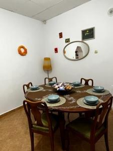 a dining room table with four chairs and a mirror at House of Julia in Sighişoara