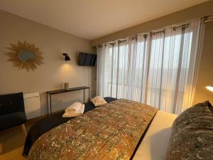 Una cama o camas en una habitación de Logis Hôtels - Le Belvédère - Hôtel 2 étoiles et Restaurant