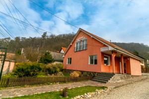 a orange house with a fence in front of it at House of Julia in Sighişoara