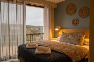 Una cama o camas en una habitación de Logis Hôtels - Le Belvédère - Hôtel 2 étoiles et Restaurant