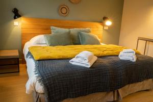 Una cama o camas en una habitación de Logis Hôtels - Le Belvédère - Hôtel 2 étoiles et Restaurant