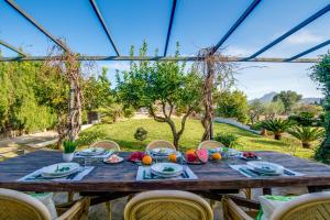 - une table en bois avec de la nourriture au-dessus de la cour dans l'établissement Ideal Property Mallorca - Sa Vinya Vella, à Alcúdia