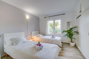 two beds in a room with white walls at Ideal Property Mallorca - Sa Vinya Vella in Alcudia +45 photos