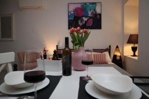 a dining room with a table with white plates and wine bottles at "Art Studio" Old Town Rovinj-Holiday in Rovinj
