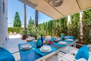 una mesa azul para cenar en un patio con palmeras en Barcares Nou, en Alcudia