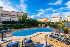 einen Pool in einem Innenhof mit Stühlen und Gebäuden in der Unterkunft Ideal Property Mallorca - Son Moleto in Sa Ràpita