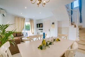ein Wohnzimmer mit einem weißen Tisch und einer Flasche Wein in der Unterkunft Ideal Property Mallorca - Son Moleto in Sa Ràpita