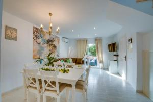 ein weißes Esszimmer mit einem weißen Tisch und Stühlen in der Unterkunft Ideal Property Mallorca - Son Moleto in Sa Ràpita