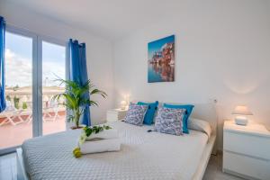 ein Schlafzimmer mit einem großen Bett mit blauen Akzenten in der Unterkunft Ideal Property Mallorca - Son Moleto in Sa Ràpita