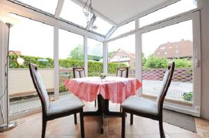 a dining room with a table and chairs and windows at Ferienwohnung Riegstra in Esens