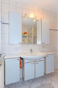 a bathroom with a sink and a mirror at Ferienwohnung Riegstra in Esens