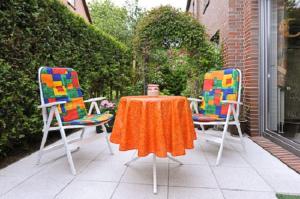 two chairs and a table and a table and two chairs at Ferienwohnung Riegstra in Esens