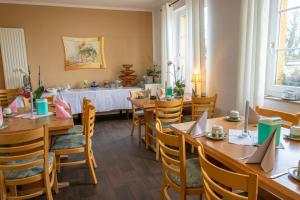 een eetkamer met houten tafels en stoelen bij Pension bei Stralsund in Prohn