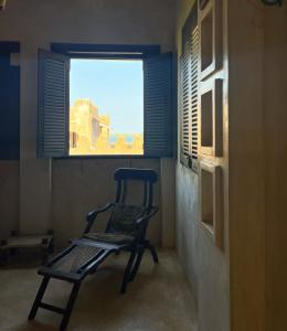 
a chair sitting in front of a window in a room at Subira House in Lamu
