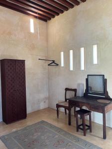 
a room with a chair and a tv at Subira House in Lamu

