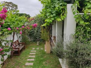 a garden with pink flowers and a bench at Sunny Lane in Franschhoek